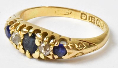 Lot 759 - An 18ct yellow gold ring set with three blue...