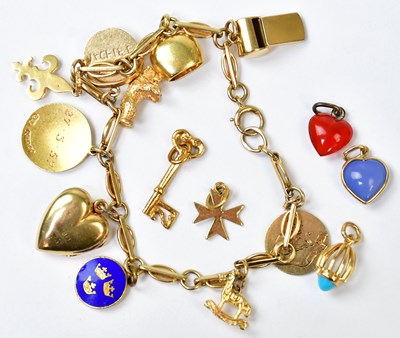 Lot 778 - A 9ct yellow gold bracelet set with ten charms,...
