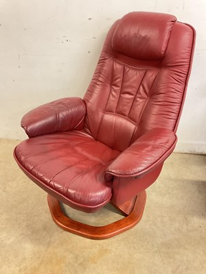 Lot 702 - A red leather stressless chair and stool.