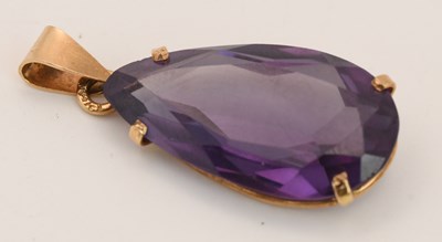 Lot 1494 - A yellow metal mounted amethyst drop pendant,...