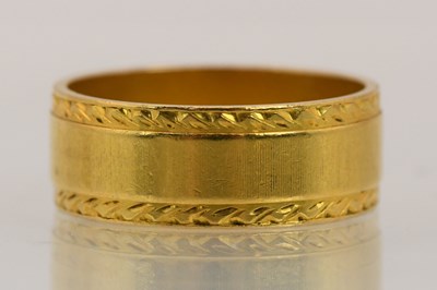 Lot 1359 - A 22ct yellow gold band ring, with bright cut...