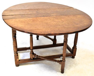 Lot 20 - A George III oak gateleg drop-leaf supper...