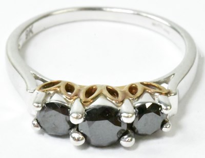Lot 753 - A 9k white gold ring set with three black...