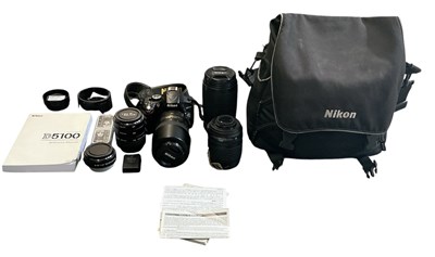 Lot 534 - NIKON; a D5100 camera, with three assorted...