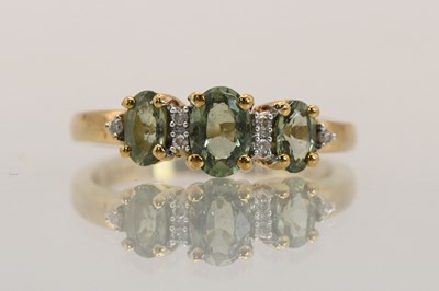 Lot 1436 - A 9ct yellow gold peridot and diamond set...
