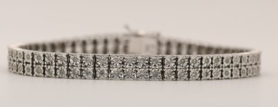 Lot 1534 - A 9ct white gold double line diamond bracelet,...