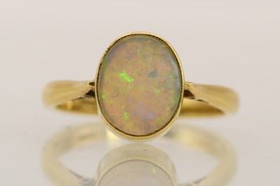 Lot 1362 - An 18ct yellow gold ring with oval opal in...