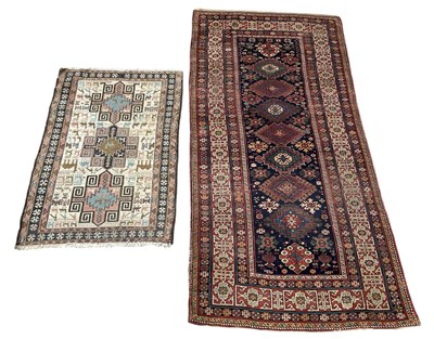 Lot 159 - Two vintage hand woven red ground carpets,...