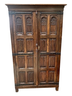 Lot 74 - A carved oak Priory style wardrobe, with linen...