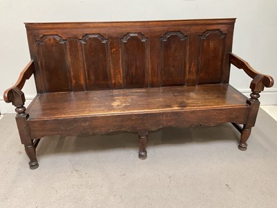Lot 51 - An 18th century carved and panelled oak settle,...