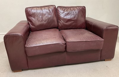 Lot 32 - A modern burgundy leather two seater sofa