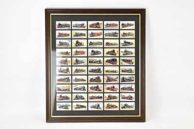 Lot 794 - A framed display of Wills train themed...