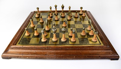 Lot 442 - A brass chessboard mounted in a wooden frame...