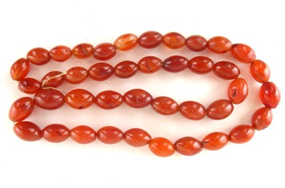 Lot 1264 - A modern string of oval amber beads, length 60cm.