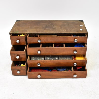 Lot 447 - MECCANO; a seven-drawer chest containing a...