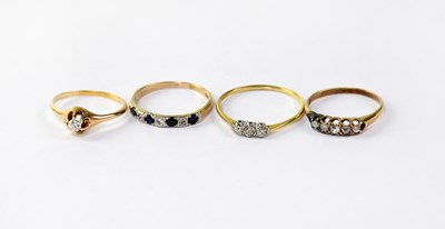 Lot 1026 - Four gold rings set with diamonds comprising...