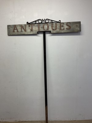 Lot 576 - A tall wooden 'Antiques' painted sign on...