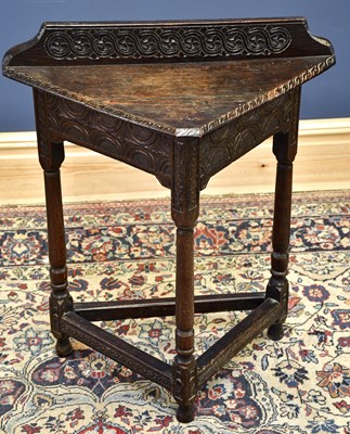 Lot 1678 - A late Victorian carved oak triangular table...