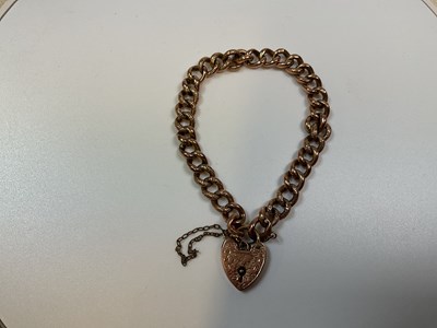 Lot 320 - A 9ct rose gold bracelet with engraved padlock...