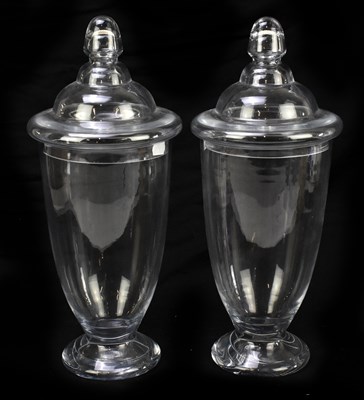 Lot 518 - A large pair of clear glass jars and covers...