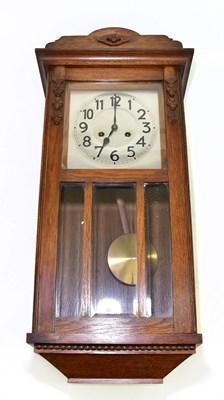 Lot 1482 - A 1930s oak wall clock, the dial set with...