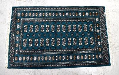 Lot 92 - A red ground Bokhara design rug and a green...