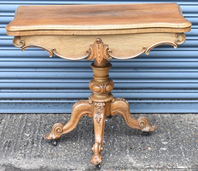 Lot 64 - A Victorian walnut card table with fold over...