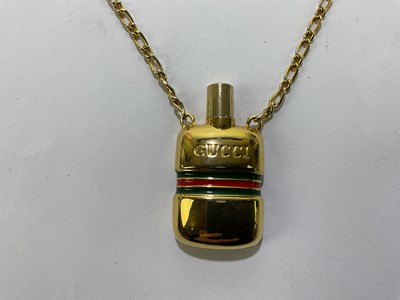 Lot 594 - GUCCI; a vintage glass perfume bottle pendant...