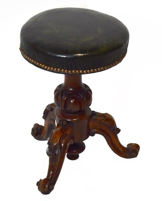 Lot 1577 - A Victorian carved walnut revolving piano...