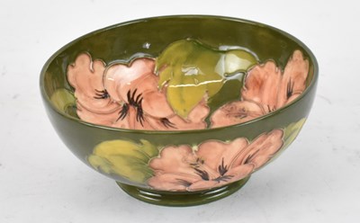 Lot 445 - MOORCROFT; a green ground bowl decorated in...