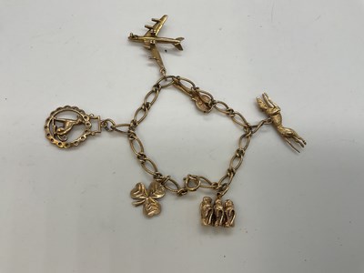 Lot 1167 - A 9ct yellow gold rope link charm bracelet,...