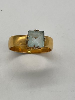 Lot 1198 - An 18ct broad yellow gold ring set with pale...