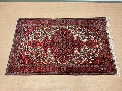 Lot 355 - A Persian inspired rug with central shaped...
