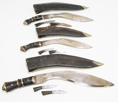 Lot 710 - Three kukri daggers in leather scabbards...