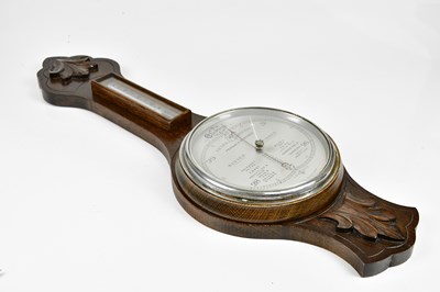 Lot 2254 - A carved oak aneroid barometer with silvered...