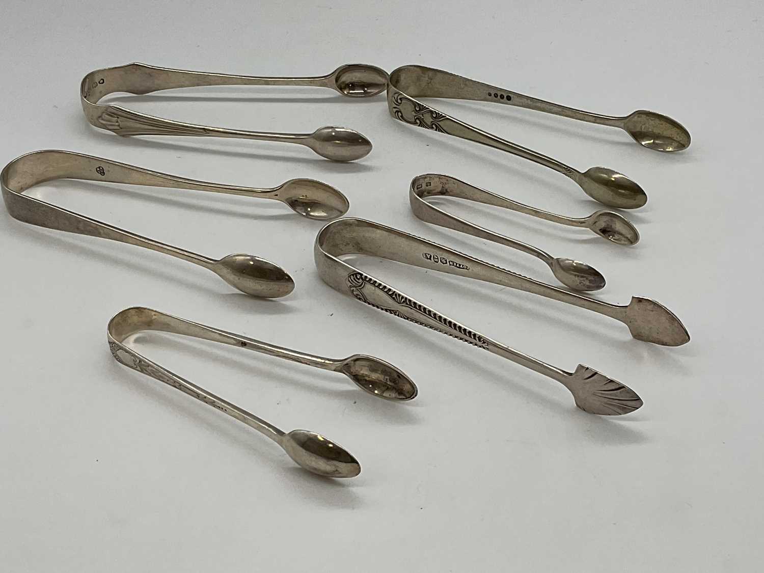 Lot 1045 - Five pairs of hallmarked silver sugar tongs...