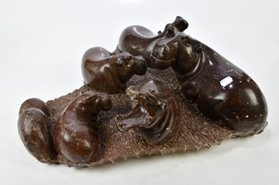 Lot 1220 - A soapstone figure group of a bloat of hippos,...
