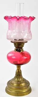 Lot 1181 - A late Victorian oil lamp, the cranberry and...