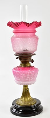 Lot 1185 - A late Victorian oil lamp, the cranberry and...