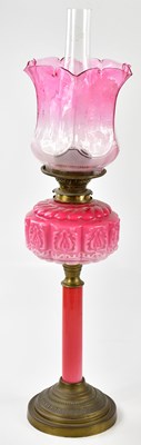 Lot 1187 - A late Victorian oil lamp, the cranberry and...