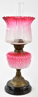 Lot 1189 - A late Victorian oil lamp, the cranberry and...