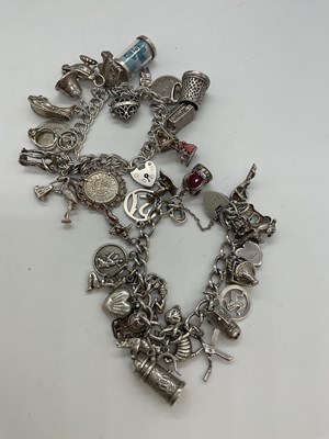 Lot 1241 - Two silver charm bracelets set with numerous...