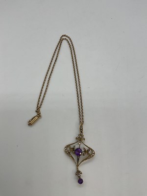 Lot 1186 - A 15ct yellow gold chain suspending an Art...