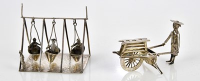Lot 2579 - A Chinese white metal figure of man pushing...