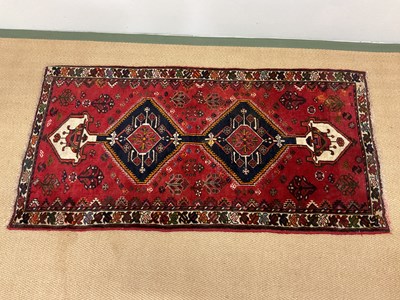 Lot 357 - A small Tekke red ground rug set with lozenge...