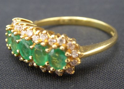 Lot 1005 - An 18ct gold emerald and diamond cluster ring