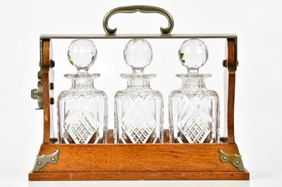 Lot 1373 - An Edwardian oak three section tantalus,...