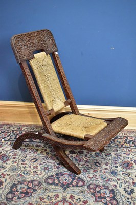 Lot 1189 - An Indonesian hard wood carved folding nursing...