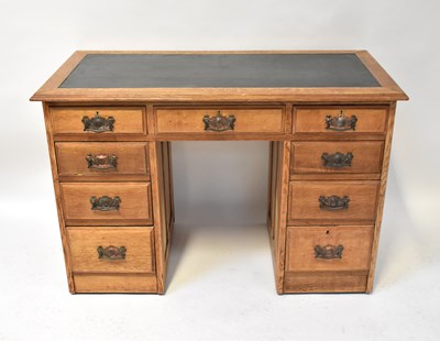 Lot 58 - An Edwardian oak nine-drawer kneehole desk,...