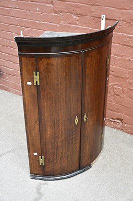 Lot 2572 - A Georgian oak bow front hanging corner...